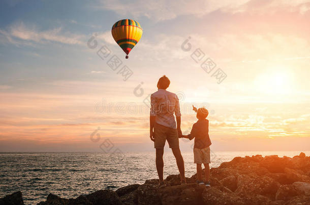 父亲和儿子在海边看气球