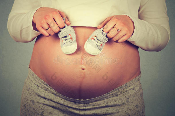 孕妇肚子上未出生婴儿穿的小鞋子