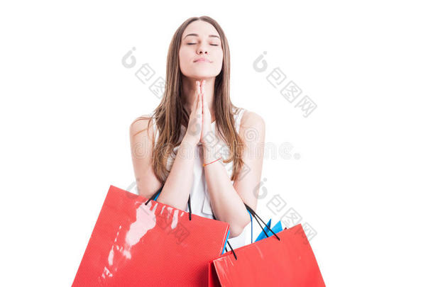有魅力的女孩带着购物袋祈祷或许愿