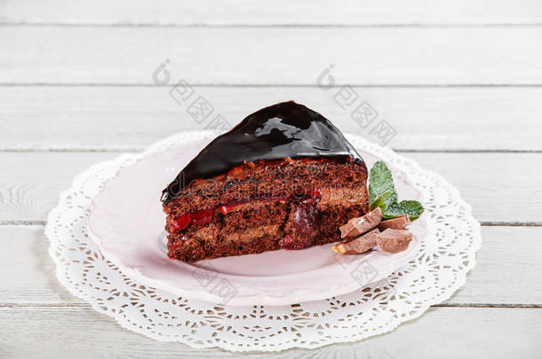 黑巧克力蛋糕与巧克力奶油和糖霜，与<strong>樱桃</strong>在盘子，在<strong>一个</strong>轻木背景
