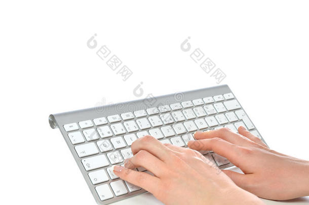 双手在办公室的远程无线计算机键盘上打字