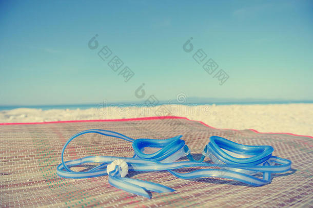 白色沙滩上的蓝色<strong>泳镜</strong>；褪色的复古风格
