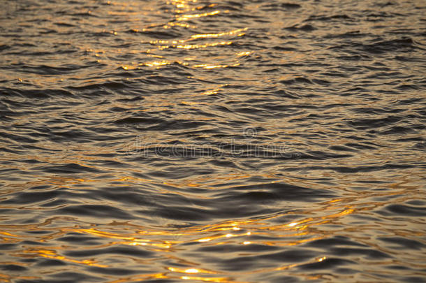 背景照片，太阳眩光在深色海水与波浪图案，选择焦点