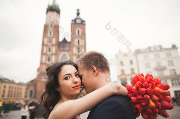 优雅美丽的新婚夫妇走在克拉科夫的主广场上