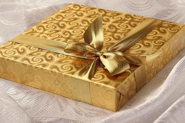 圣诞礼物，<strong>金色纸</strong>，白色背景上有蝴蝶结