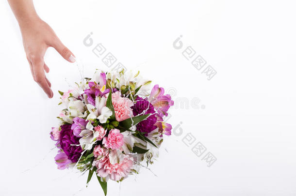 手从粉红色和紫色的百合花和白色的蔷薇花中收到一束柔和的花束