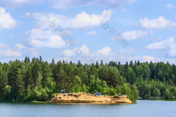 森林湖有清澈的水和岛上休息的游客和旅行者，自然景观蓝天