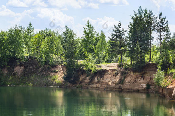 海岸森林湖有晶莹剔透的水，这反映了树木，美丽的风景蓝天