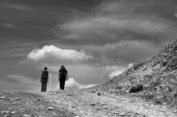 活跃的年轻夫妇在山路上。 愉快的徒步旅行。 山景