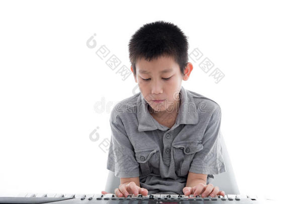 亚洲男孩在白色上玩键盘。