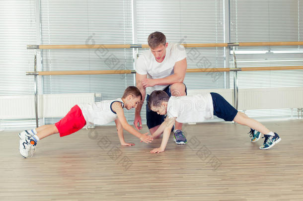 一群孩子在健身房和托儿所老师一起做孩子体操