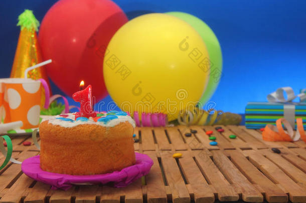生日蛋糕与蜡烛在乡村木桌上与彩色气球的背景