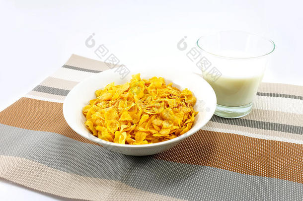 玉米片和一杯牛奶放在五颜六色的桌子垫子上