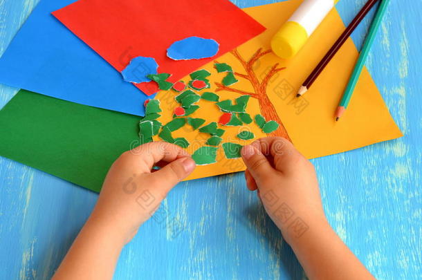 孩子把彩色纸撕成碎片。 家庭活动，提高精细运动技能的发展。 宝贝玩。 如何使用纸张