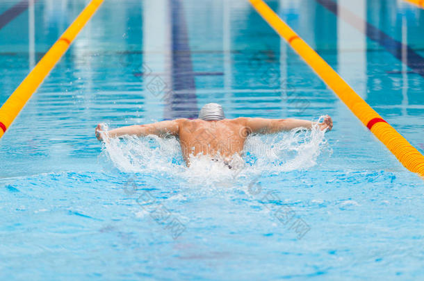 动态和适合的游泳者在帽呼吸执行蝶泳