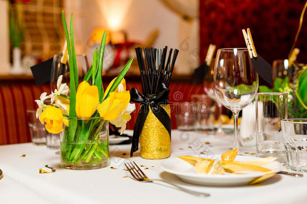 生日客人餐桌设置与新鲜的花黑色和金色风格，室内
