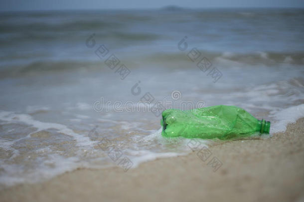 空绿色塑料瓶遗弃在海滩上，照片不污染，不乱扔垃圾