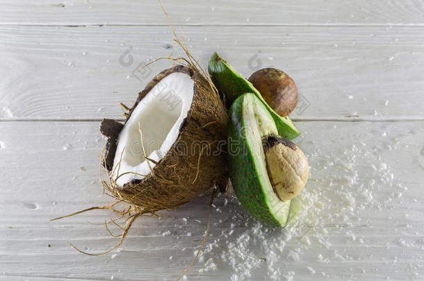 新鲜，美味的椰子与鳄梨在一个木制的白色背景