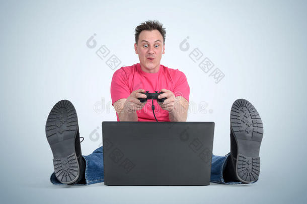 有趣的男人游戏者坐在地板上玩<strong>笔记本</strong>电脑