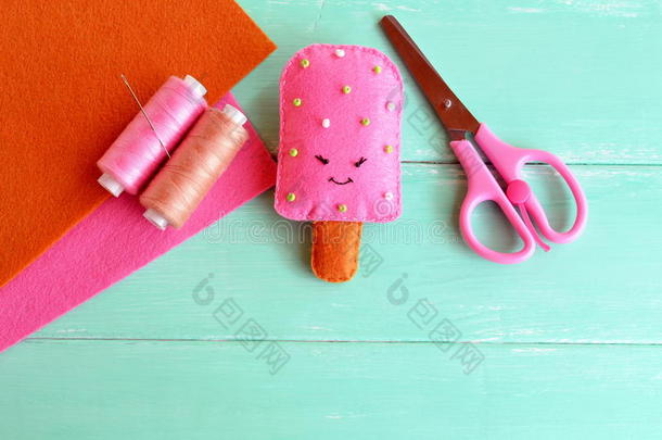 手可爱的毡冰淇淋玩具。 粉红色羊毛冰淇淋和珠子刺绣。 线，针，剪刀，毡片。