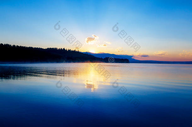 美丽的风景与山和湖在黎明的金色，蓝色和紫色的色调。 斯洛伐克LiptovskaMara，在该地区