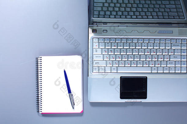 办公室里的桌面有笔记本电脑和笔记本电脑