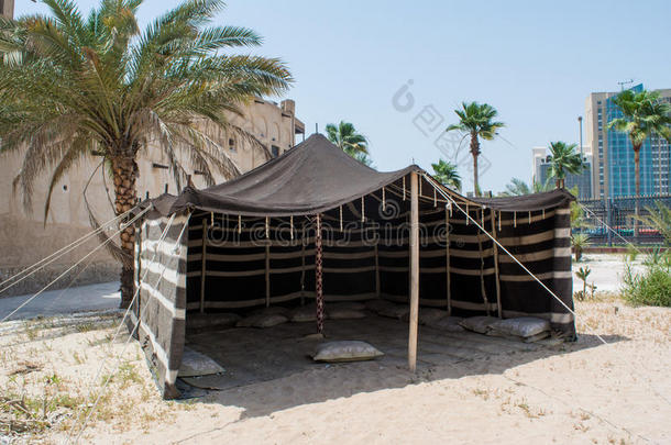 阿拉伯古老风格的展位在棕榈树附近的沙子上