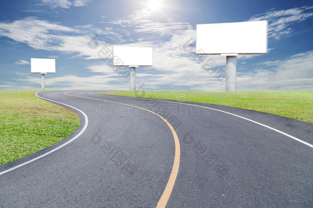 空白广告牌为您的广告与文字的空间在道路曲线，绿草和蓝天白云。