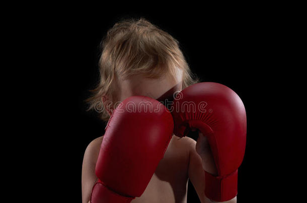 男孩运动员，拳击手或跆拳道手套训练在黑色背景。