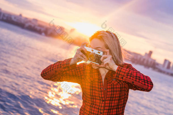 美丽的女孩在日落复古相机拍摄
