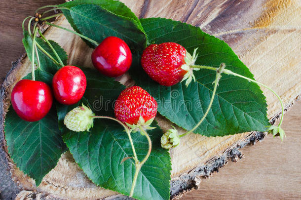 木制背景上新鲜成熟的有机草莓和樱桃。 乡村风格。