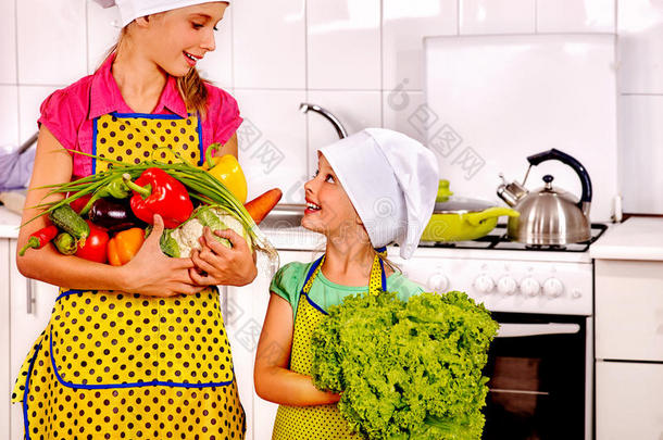 孩子们小女孩在厨房煮蔬菜。