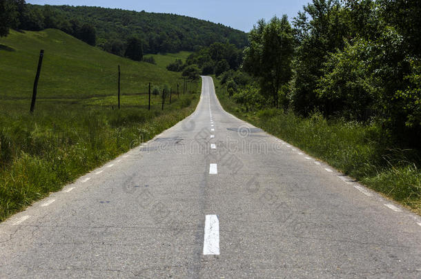 农村的空沥青路，道路的弯道，巴的田野