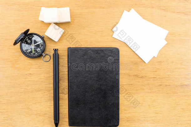 黑色笔记本，钢笔，指南针和名片在木桌上，模拟
