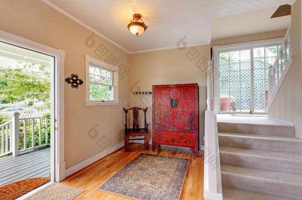 入口通道区域以柔和的色调与楼梯，虚荣红色橱柜和硬木地板。