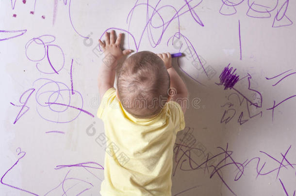 小男孩在石膏板墙上画画