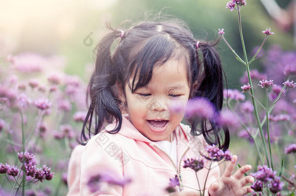 快乐的小女孩在花圃里奔跑嬉戏