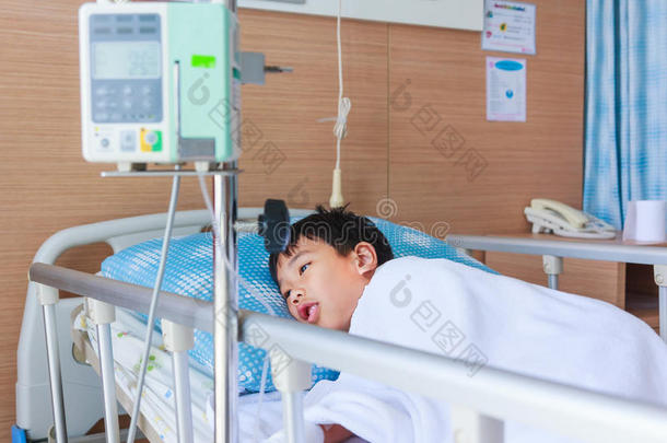 亚洲男孩躺在<strong>病床</strong>上，用输液泵静脉滴注。