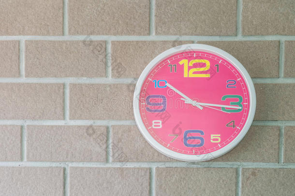 特写粉红色墙壁时钟在砖墙纹理背景