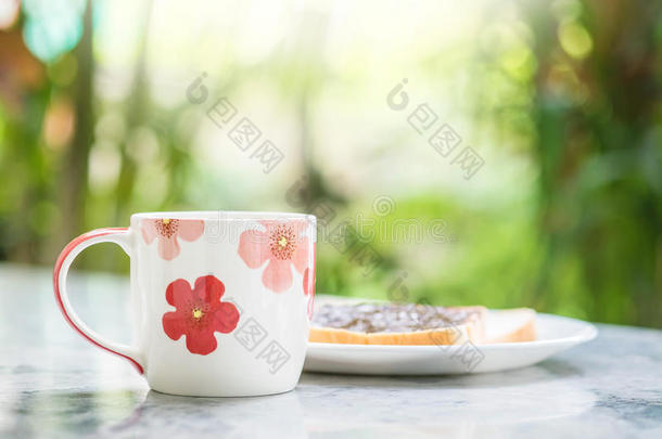 特写可爱的杯子在模糊的大理<strong>石桌</strong>子和花园景观在早晨纹理背景