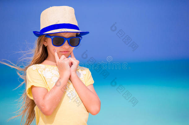 暑假期间，可爱的小女孩在海滩上吃防晒霜