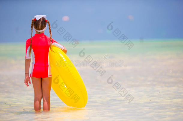 可爱的小女孩，充气橡胶圈在海滩度假。 孩子们在暑假里玩得很开心