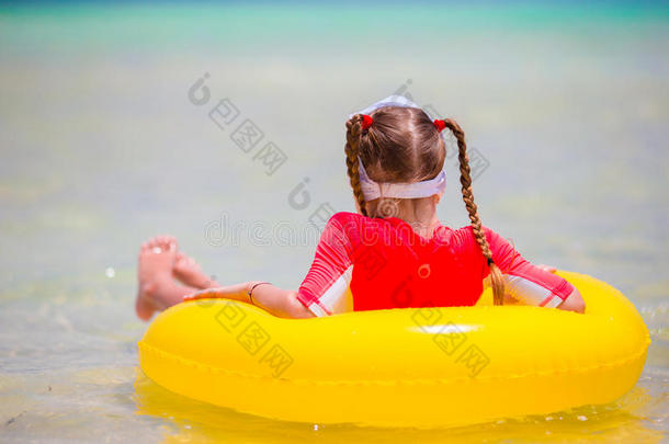 可爱的小女孩，充气橡胶圈在海滩度假。 孩子们在暑假里玩得很开心