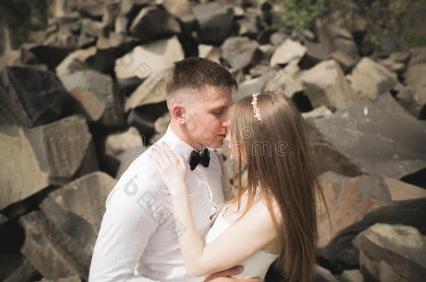 华丽的新娘，新郎亲吻和拥抱在悬崖附近，有惊人的景色