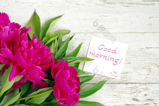 早上好！ 一束粉红色的牡丹花和带有铭文的白色卡片早上好！