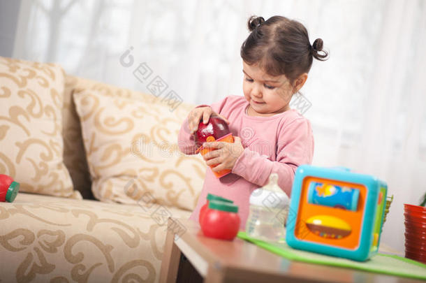 可爱的小女孩在房间里玩玩具，孩子和玩具