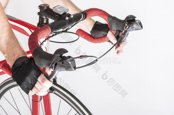 骑自行车的人双手戴着手套放在车把上。 按下前<strong>后刹车</strong>杠杆。