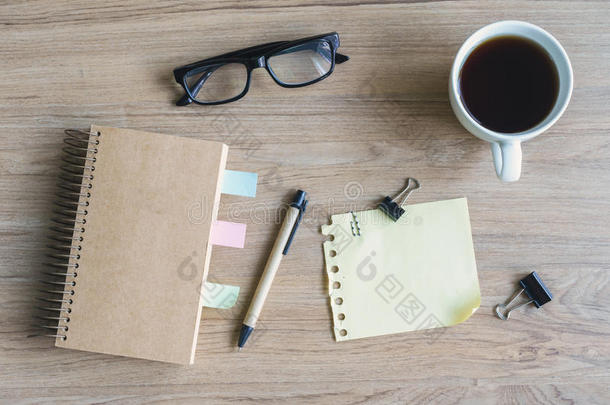 一杯咖啡，上面有空白笔记本和木桌上的记事本