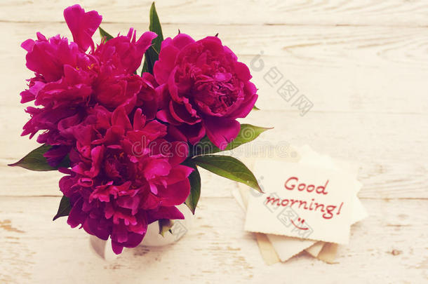 早上好！ 一束粉红色的牡丹花和带有铭文的白色卡片早上好！