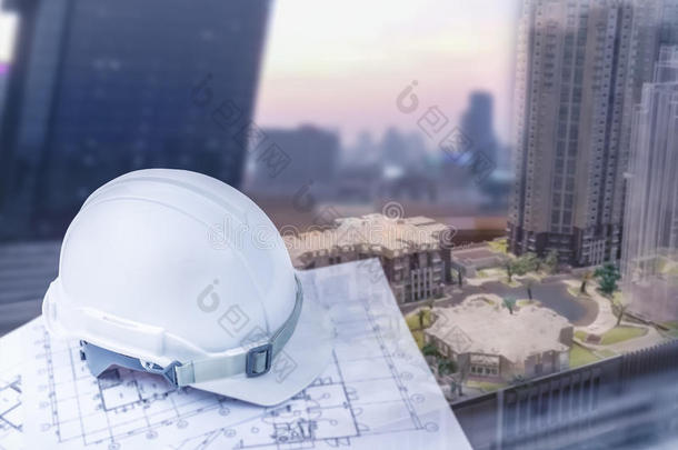 工程师头盔与建设计划和模糊城市建设背景